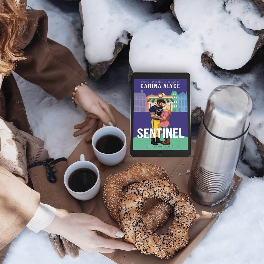 Person in snowy setting with coffee, bagel, and 'Sentinel' book by Carina Alyce.