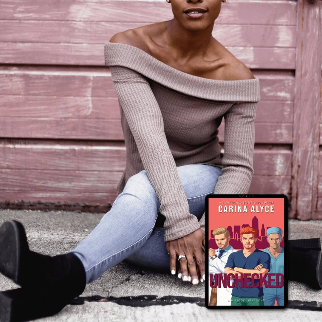 Woman sitting on a bench with a book titled 'Unchecked' by Carina Alyce next to her.