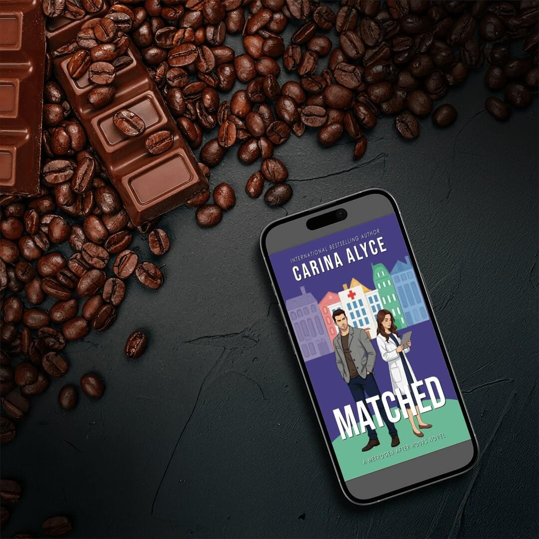 Phone displaying 'Matched' book cover with coffee beans and chocolate bars on a dark surface