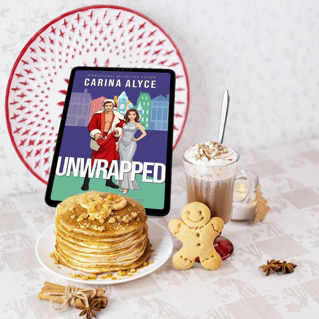 Tablet displaying 'Unwrapped' by Carina Alyce with pancakes and hot chocolate on a table.