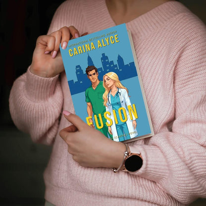 Person holding a book titled 'Fusion' by Carina Alyce