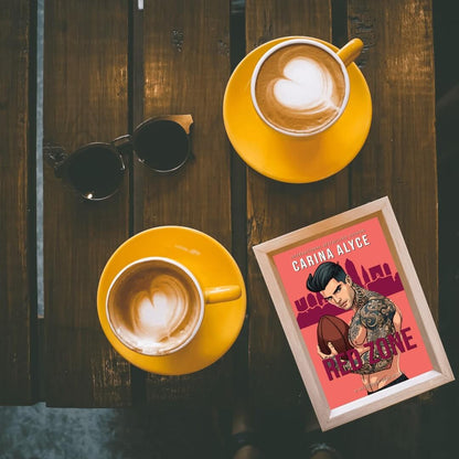 Two yellow coffee cups with a framed poster on a wooden surface