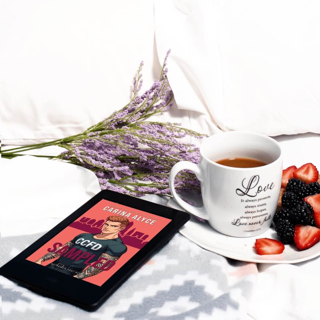 Tablet displaying a book cover, white mug with 'Love' text, and plate with berries on a white surface.