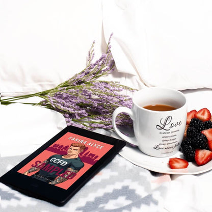 Tablet displaying a book cover, white mug with 'Love' text, and plate with berries on a white surface.