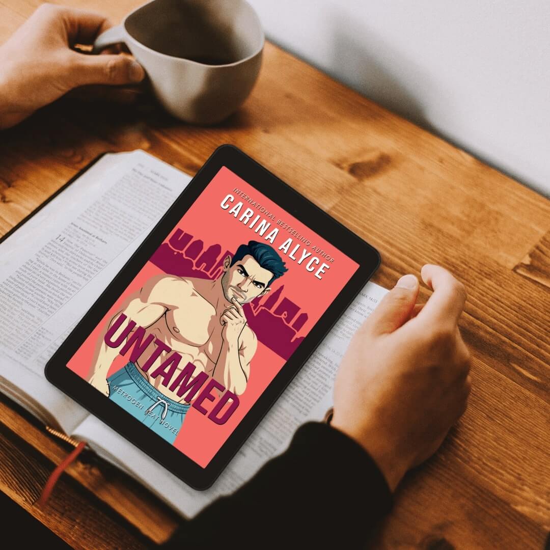 Person holding a tablet with a book cover on a wooden table